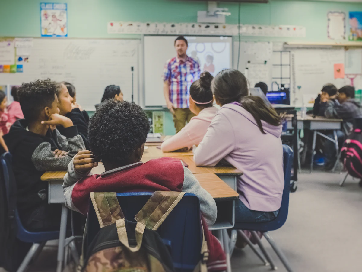 Une classe d'élèves attentifs pendant qu'un enseignant présente au tableau